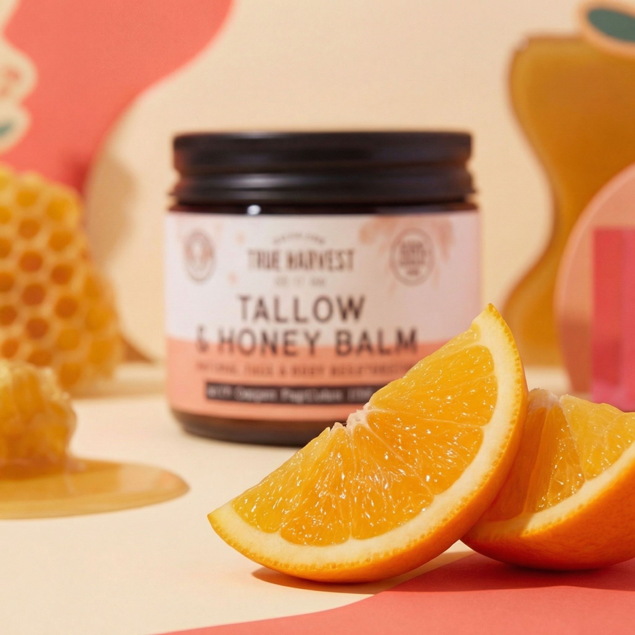 Tallow and honey balm jar with oranges and honeycomb on a colorful background
